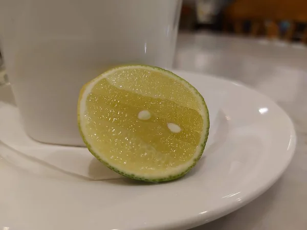 Нарезанный Лимонным Зеленым Лимоном Подается Белой Тарелке Свежий Кислый Вкус — стоковое фото