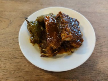 Endonezya dilinde tuzlu Ariidaeoriid yayın balığının yeşil biberli kemiği veya Tulang ikan asin jambal roti cabe gendot. Endonezya 'nın otantik gıdası. Beyaz tabakta servis ediliyor. izole arkaplan 