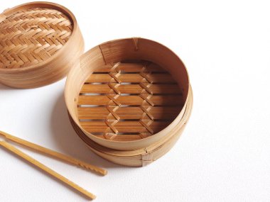 traditional steamer from bamboo.  commonly used for steaming dim sum.  isolated background in white.  copyspace.