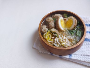 Yumurtalı köfte. Hardal yeşillikleri, lahanalar, sarı erişteler ve ses ile tamamlanmış. Tahta kaselerde servis edilir. Lezzetli bir tat. izole edilmiş arkaplan.