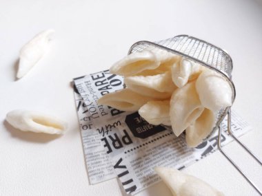 Balık cipsi ve paslanmaz çelik kızartma sepeti. Gıda seviyesinin üstünde servis edilir. izole edilmiş arka plan beyaz. minimalist ve estetik fotoğraf konsepti