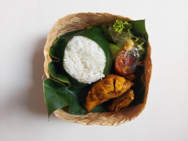 Endonezya geleneksel set yemeği. Bambu dokuma kutusunda muz yaprağında servis ediliyor. Pirinç, kızarmış tavuk, acı biber ve maruldan oluşur. Lezzetli