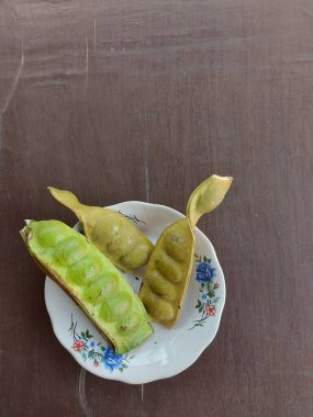 Tabakta Parkia Specosa. Aynı zamanda acı fasulye de denir, bükülmüş fasulye kümesi. Parkiain familyasından, Fabaceae familyasından bir bitki türü. Yenilebilir bitki