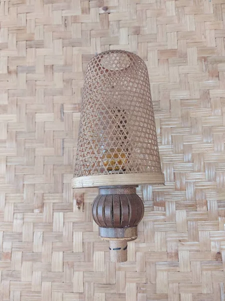 vintage bamboo wall lamp on woven bamboo wall.  classic and aesthetic decorative lamp