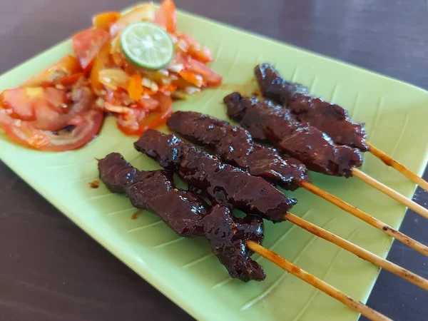 sate maranggi. Geleneksel Purwakarta, Endonezya yemekleri. Tavuk ya da soya soslu biftek ve baharattan yapılır. Taze çiğ domates sosu ve dilimlenmiş limonla tamamlandı.