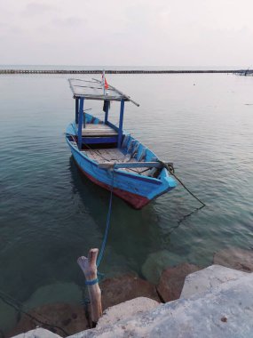 Mavi ahşap tekne kıyıya yanaştı. minimalist fotoğrafçılık konsepti
