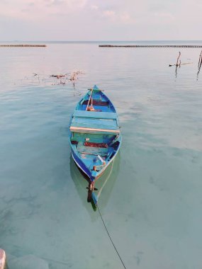 Mavi ahşap tekne kıyıya yanaştı. minimalist fotoğrafçılık konsepti