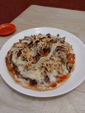 Bir tabak kuzu pizza. Biber sosuyla tamamlanmış.. 
