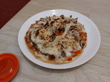 Bir tabak kuzu pizza. Biber sosuyla tamamlanmış.. 