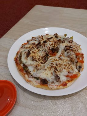 Bir tabak kuzu pizza. Biber sosuyla tamamlanmış.. 