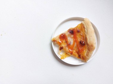 A sliced of pizza on white plate. Isolated background in white