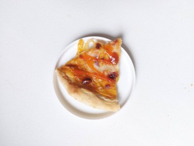 A sliced of pizza on white plate. Isolated background in white