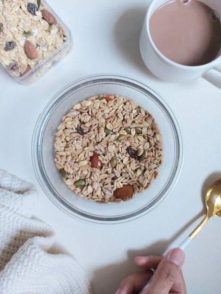 Overnight oat meal with dried fruit and grains on a bowl. Completed with golden spoon. Healthy breakfast. Isolated background in white.