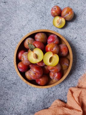 Ahşap kasede erik meyvesi yığını. İzole edilmiş arkaplan