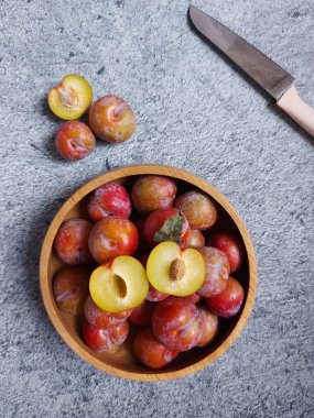 Ahşap kasede erik meyvesi yığını. İzole edilmiş arkaplan