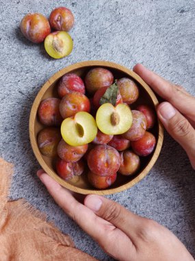 Ahşap kasede erik meyvesi yığını. İzole edilmiş arkaplan