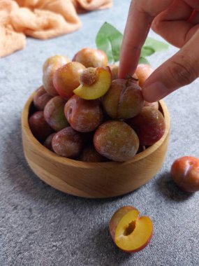 Ahşap kasede erik meyvesi yığını. İzole edilmiş arkaplan