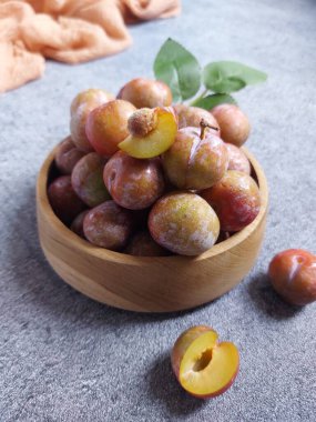 Ahşap kasede erik meyvesi yığını. İzole edilmiş arkaplan