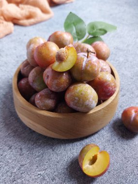 Ahşap kasede erik meyvesi yığını. İzole edilmiş arkaplan