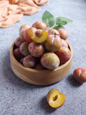 Ahşap kasede erik meyvesi yığını. İzole edilmiş arkaplan