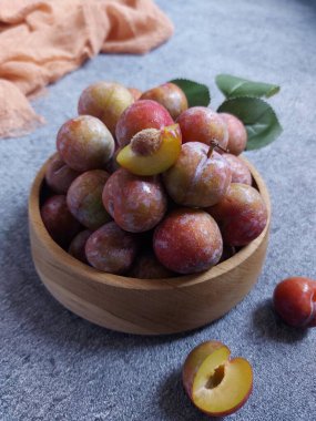 Ahşap kasede erik meyvesi yığını. İzole edilmiş arkaplan