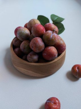 Ahşap kasede erik meyvesi yığını. İzole edilmiş arkaplan