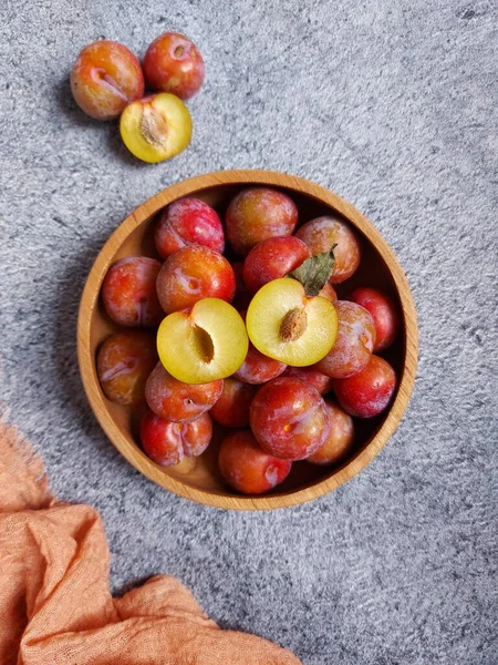 Ahşap kasede erik meyvesi yığını. İzole edilmiş arkaplan