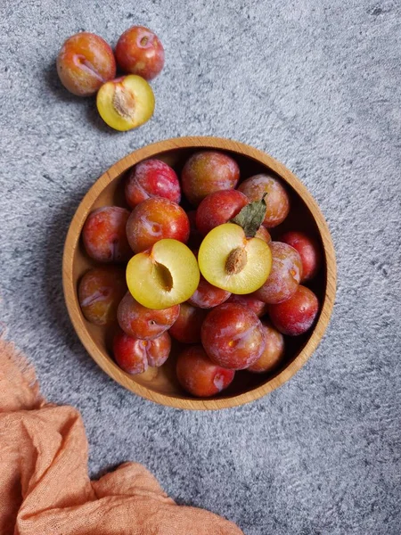 Ahşap kasede erik meyvesi yığını. İzole edilmiş arkaplan