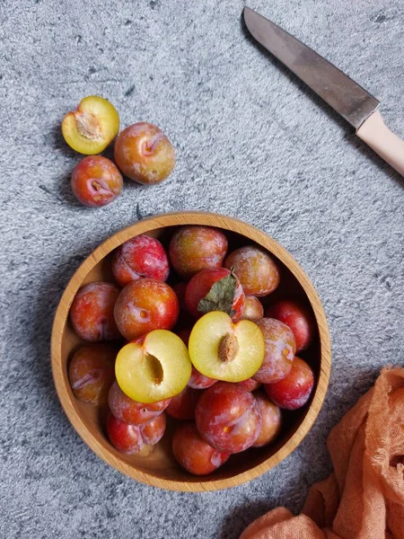 Ahşap kasede erik meyvesi yığını. İzole edilmiş arkaplan