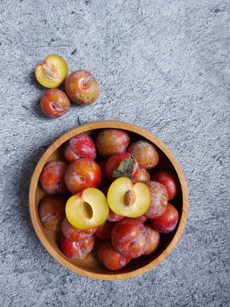 Ahşap kasede erik meyvesi yığını. İzole edilmiş arkaplan