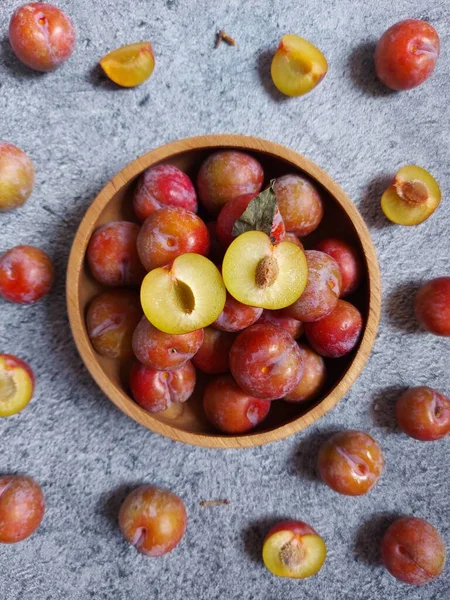 Ahşap kasede erik meyvesi yığını. İzole edilmiş arkaplan