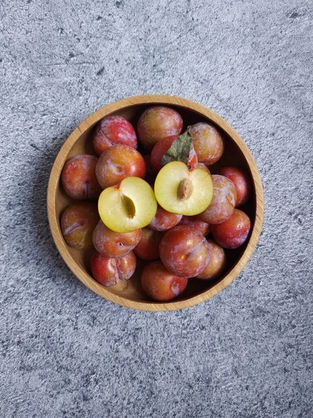 Ahşap kasede erik meyvesi yığını. İzole edilmiş arkaplan