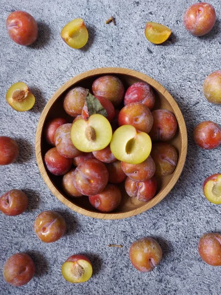 Ahşap kasede erik meyvesi yığını. İzole edilmiş arkaplan