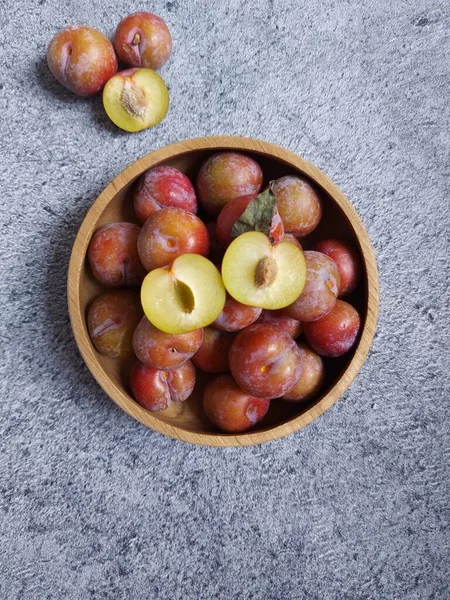 Ahşap kasede erik meyvesi yığını. İzole edilmiş arkaplan