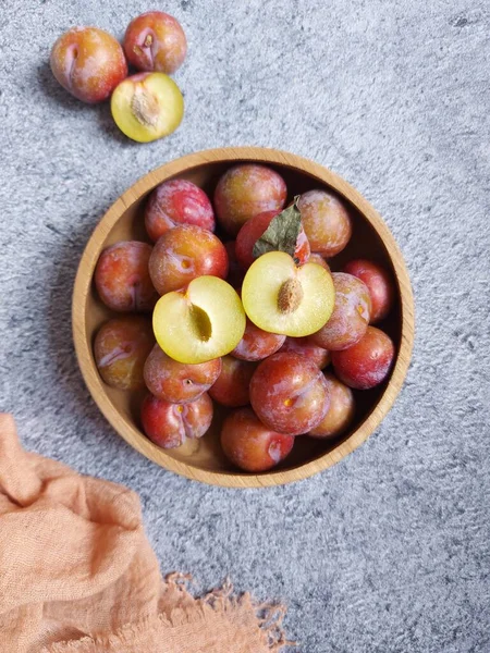 Ahşap kasede erik meyvesi yığını. İzole edilmiş arkaplan