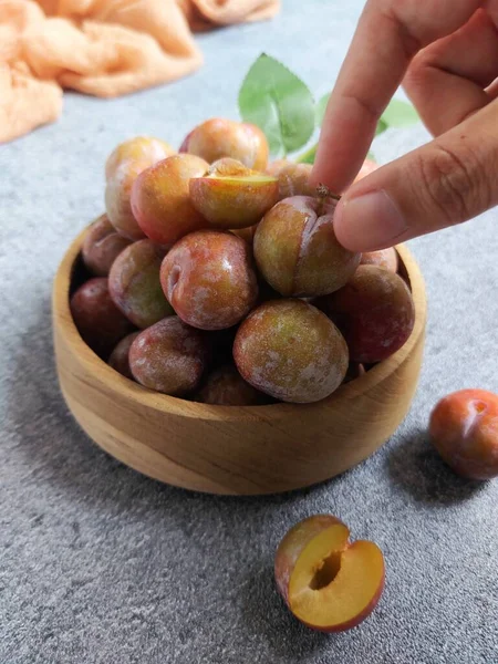 Ahşap kasede erik meyvesi yığını. İzole edilmiş arkaplan