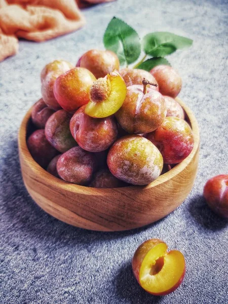 Ahşap kasede erik meyvesi yığını. İzole edilmiş arkaplan