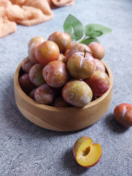 Ahşap kasede erik meyvesi yığını. İzole edilmiş arkaplan