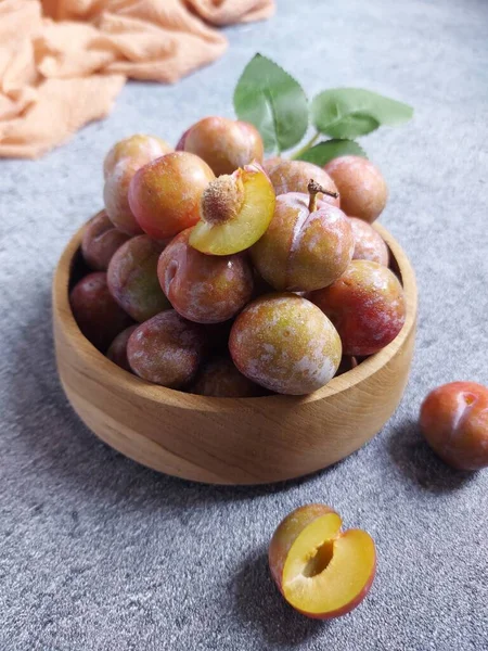 Ahşap kasede erik meyvesi yığını. İzole edilmiş arkaplan