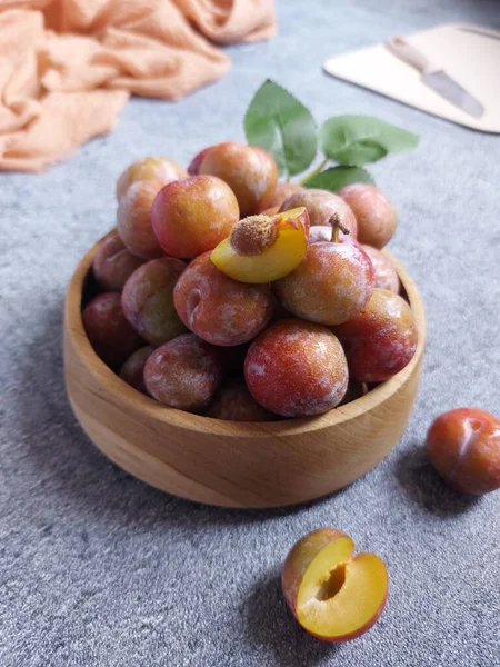 Ahşap kasede erik meyvesi yığını. İzole edilmiş arkaplan