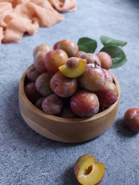 Ahşap kasede erik meyvesi yığını. İzole edilmiş arkaplan