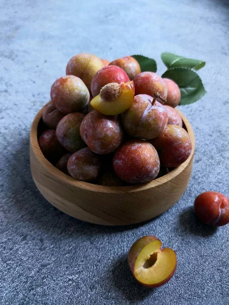 Ahşap kasede erik meyvesi yığını. İzole edilmiş arkaplan