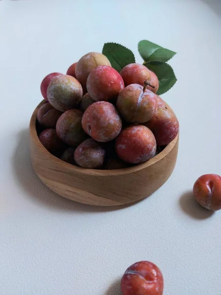 Ahşap kasede erik meyvesi yığını. İzole edilmiş arkaplan