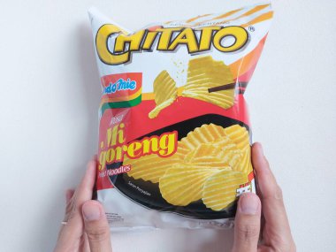 Bogor, Endonezya-Eylül-24 2022: kızarmış erişte aromalı chitato. Plastik pakette patates cipsi var. Endonezya pazarı için perakende ürün. Lezzetli atıştırmalıklar. izole edilmiş arkaplan