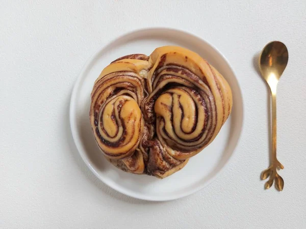 Beyaz Tabakta Çikolata Kıvrımlı Çörek Yumuşak Tatlı Bir Tat Minimalist — Stok fotoğraf