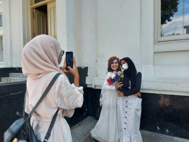 Bandung, Endonezya-11 Eylül 2022: Jalan Asya Afrika, Bandung Batı Java, Endonezya 'da açık hava turizm atmosferi. Çeşitli ünlü karakterleri canlandıran insanların olduğu fotoğraf noktası.