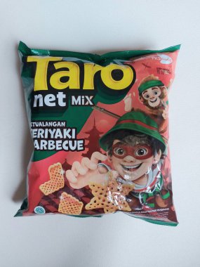 Bogor, Endonezya-Ekim 12 2022: taro net karışımı. Endonezya perakende ürünleri için bir marka. Frambuazlı atıştırmalıklar. Plastik ambalajla servis edilmiş. Lezzetli. İzole edilmiş arkaplan beyaz.