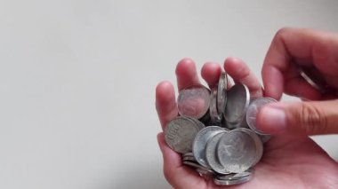 Kadın rupiah paraları sayıyor. İzole edilmiş arkaplan beyaz