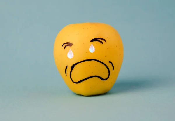 crying sad Face on an apple - abstract image of bad scary human emotions background