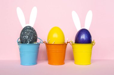 Renkli kovalarla tavşan kulaklarıyla çok renkli paskalya yumurtaları boyadılar. Mutlu Paskalyalar Kartı